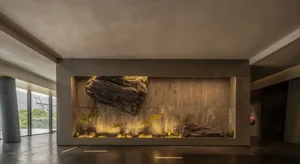 A modern living space with a large rock wall and artificially created waterfall, adding depth and interest to the environment