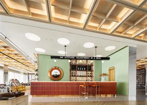Inviting coffee shop with a bar area featuring a counter and stools, surrounded by comfortable seating and beverage cups