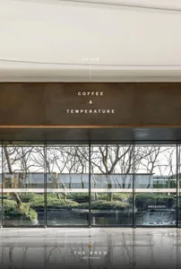 現代辦公空間擁有大型玻璃牆、咖啡與溫度指示牌，以及窗戶自然光
