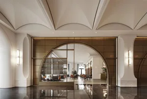 Elegant hotel lobby with a grand archway entrance, comfortable seating areas, and dining tables, set against a neutral background
