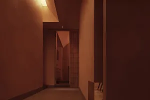 Cozy hallway with a brown brick wall, two chairs, and a doorway leading to another room