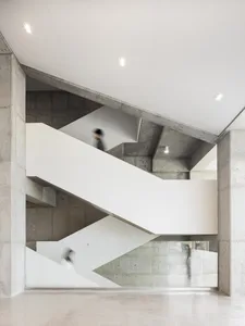 A rendered interior scene of a staircase with concrete steps, two people walking down, and a neutral background