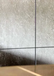 A minimalist indoor space with a concrete wall and a tiled surface, devoid of objects or people