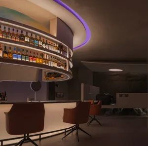 A circular bar counter with liquor bottles and seating for patrons in a warm and inviting atmosphere