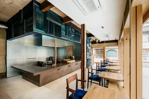 Warm and inviting restaurant interior with wooden floors and walls, featuring dining tables and chairs
