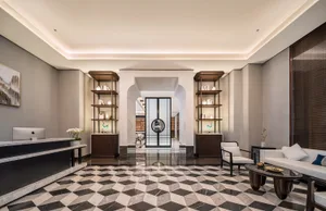 A marble-floored lobby with two chairs and decorative vases, creating a welcoming atmosphere