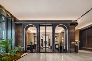 A luxurious hallway with a black marble floor, potted plants, chairs, and dining tables, exuding elegance and refinement