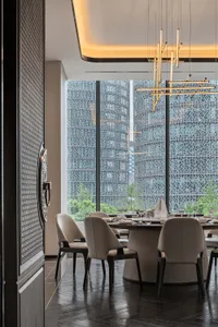 精緻餐廳空間，設有大型餐桌準備用餐，周圍環繞座椅與酒杯