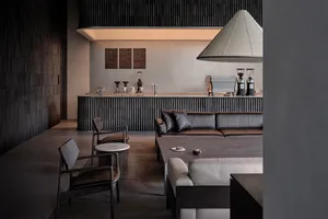 Open living area with a large couch, chairs, and dining table, well-lit and inviting, with clean lines and minimalistic elements