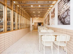 A modern dining area with a long white table surrounded by metal chairs, creating a comfortable and inviting space for gatherings