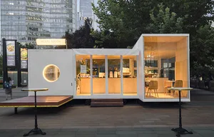 Open living space with a modern kitchen, dining area, and minimalist decor, featuring a dining table, chairs, and a bench
