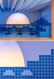 Modern restaurant interior with multiple dining tables and chairs, creating a comfortable atmosphere for guests