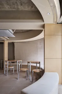 Empty restaurant interior with wooden walls and floors, featuring chairs and dining tables in a calm and inviting atmosphere