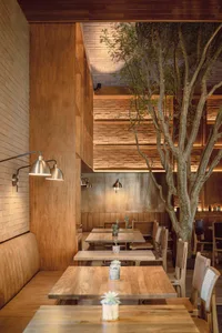 Warm and inviting restaurant interior with wooden tables and chairs, creating a cozy seating area for guests