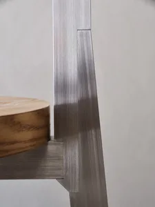 A modern room with a metal chair on a wooden table, featuring a mix of metallic and wooden elements