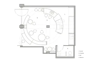 Modern living area with a circular design, featuring a dining table, kitchen, bathroom, and multiple couches, creating a comfortable and functional space