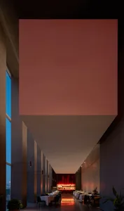 A calm and inviting hallway with pink and white walls, natural light from two windows, and a sense of serenity