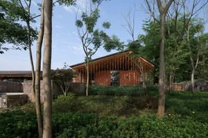 A serene photo of a house with a wooden exterior, surrounded by trees and natural foliage