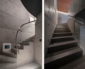 A functional staircase with concrete steps and a practical design, showcasing a black and white photo and a rendered image of the stairwell leading to the upper level