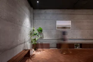 Cozy living and dining space with two benches, a potted plant, and a vase, creating a warm and inviting atmosphere