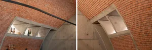 Modern building with brick walls and concrete ceiling, featuring clean lines and minimalistic design, with natural light illuminating the space