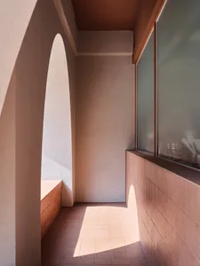 A warm and inviting hallway with a brick wall and a stone wall, featuring two benches and warm lighting