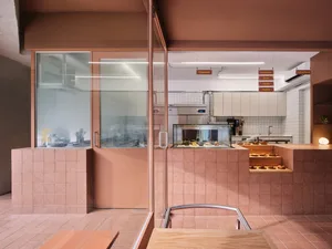 Modern restaurant kitchen with a counter, dining table, chairs, and various appliances, set in a functional and well-designed space