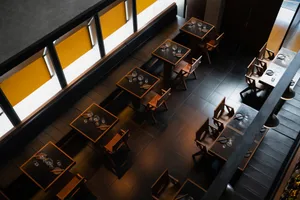 A restaurant dining area with multiple tables and chairs, creating an inviting atmosphere for socializing and meals