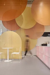 黃色牆面帶有圓形圖案的現代餐廳空間，配有餐桌與兩把椅子，營造獨特而溫馨的氛圍