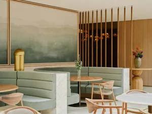 Warm and inviting restaurant interior with wooden walls and floors, comfortable seating, and a potted plant