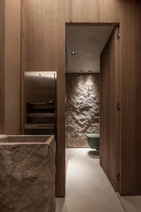 Bathroom with two sinks, a toilet, and wood paneling, creating a warm and cozy atmosphere