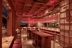 Warm and inviting restaurant interior with wooden tables and chairs, dimly lit for a relaxed ambiance