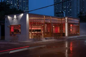 A modern Asian restaurant at night with red accents, natural light, and comfortable seating for guests