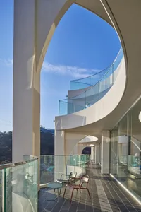 A modern hotel lobby with glass walls, clean lines, and minimal decoration, flooded with natural light and featuring high-end design elements