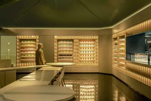 A well-lit retail store with a large glass display case filled with various bottles in different sizes and shapes, showcasing a diverse selection of products