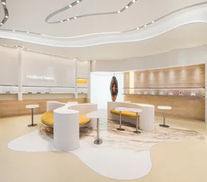 A modern showroom with white and brown walls, featuring white tables and chairs, in a clean and minimalistic atmosphere with well-designed lighting