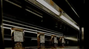 A dark room with rows of bottles on a counter, arranged in an organized manner