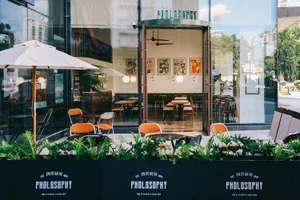 A cozy cafe with natural light, potted plants, and comfortable seating areas