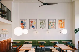 A restaurant interior with multiple dining tables and chairs, a vase on one table, and an inviting atmosphere