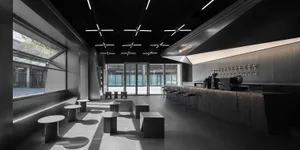 Modern cafe interior with black and white elements, chairs, and dining tables, creating an inviting atmosphere