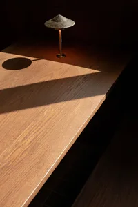 A dimly lit room with a wooden desk, a lamp, and a cozy atmosphere