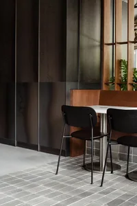 Warm and inviting restaurant interior with wooden walls and floors, featuring a dining table and chairs with metal legs
