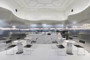 Sophisticated restaurant interior with white marble walls, wine glasses, and comfortable seating areas