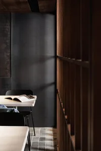 Dimly lit dining room with a wooden table and two chairs, a book resting on the table
