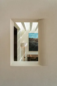 Cozy dining space with a wooden dining table and chairs, a painting on the wall, and natural light illuminating the area