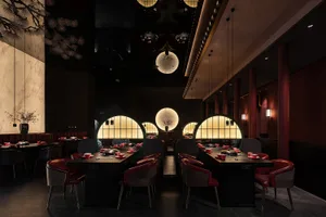 A dimly lit restaurant with empty tables and chairs, creating a moody atmosphere