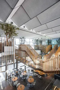 Dimly lit modern space with multiple levels, chairs, and dining tables, featuring clean lines and minimalistic decoration
