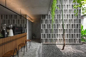 A modern restaurant bar with a brick wall, a countertop, and three chairs, creating an inviting atmosphere for dining and socializing