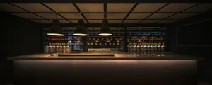 A casual bar area with a counter featuring various items on display, including bottles, cups, and bowls, in a restaurant setting