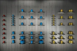 A colorful display of various blue and yellow cups arranged in a visually appealing manner on a wall, showcasing the artist's skill in creating an eye-catching and unique installation